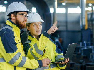 Portrait of Male and Female Industrial Engineers in Hard Hats Di