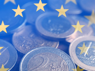 Many Euro coins on wooden table, closeup