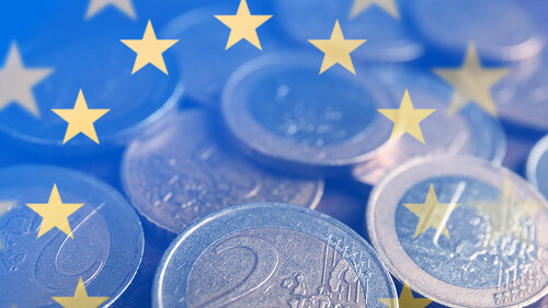 Many Euro coins on wooden table, closeup
