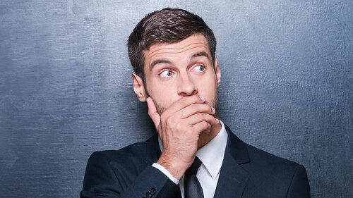 No way! Shocked young man in formalwear covering mouth with hand