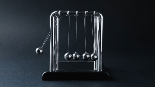 Newton's cradle on dark background. Physics law of energy conser