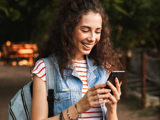 Photo of young delighted woman 18-20 with backpack, smiling and