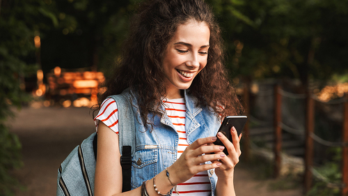 Photo of young delighted woman 18-20 with backpack, smiling and