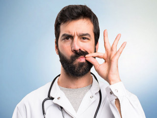 Young doctor making silence gesture on blue background