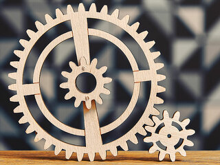 System of a wooden cogwheels on the wide wooden table