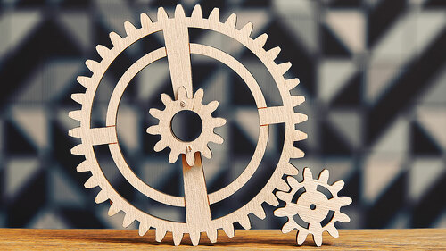 System of a wooden cogwheels on the wide wooden table