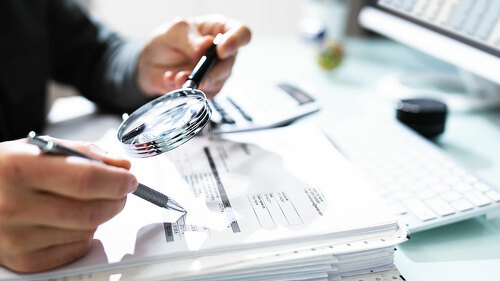 Audit And Fraud Investigation. Auditor Using Magnifying Glass