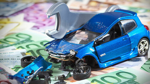 Beschädigtes Auto auf Geldscheinen