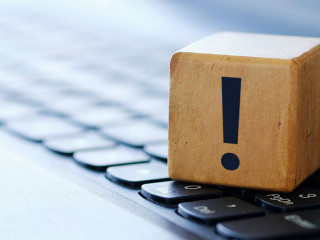 A question mark on a wooden cube on a computer keyboard