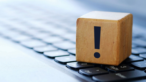 A question mark on a wooden cube on a computer keyboard