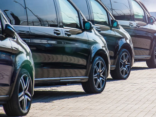 Dark colored passenger vans in a parking lot.