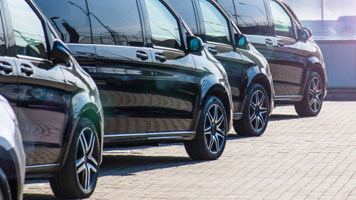 Dark colored passenger vans in a parking lot.