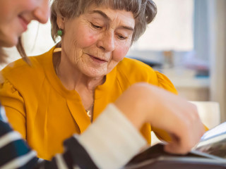 Old woman with her granddaughter look at family photos.