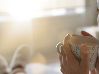 Cosy brunette at home on couch with hot drink