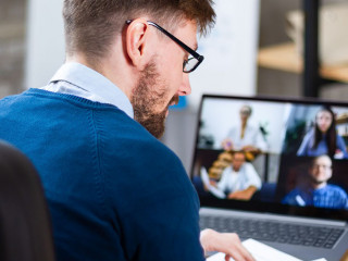 Successful confident top manager or coach, holding video confere