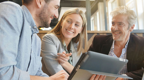 Smiling sales team working through presentation with manager