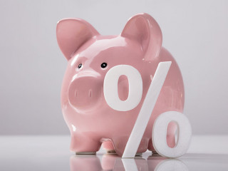 Close-up Of Percentage Sign And Piggy Bank