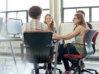 Unposed group of creative business people in an open concept office brainstorming their next project.