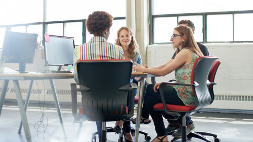Unposed group of creative business people in an open concept office brainstorming their next project.