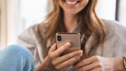 Cheerful beautiful redhead woman using mobile phone.