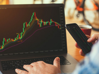 A businessman or broker works from home analyzing the stock market.