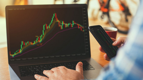 A businessman or broker works from home analyzing the stock market.