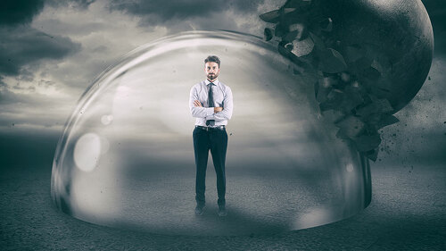 Businessman safely inside a shield dome during a storm that protects him from a wrecking ball. Protection and safety concept