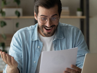 Surprised guy reading exciting news feels happy