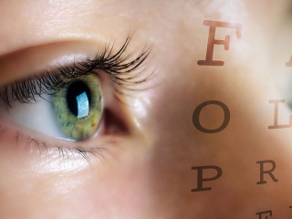 Eye of woman on background Snellen table