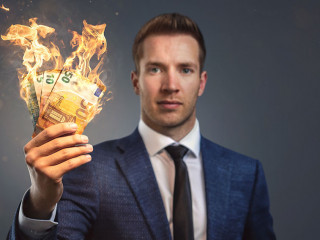 Businessman holding burning money in his hand