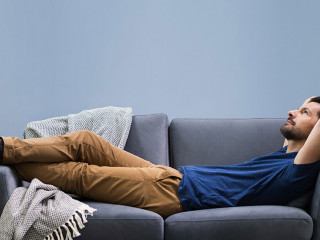 Man Relaxing On Sofa At Home