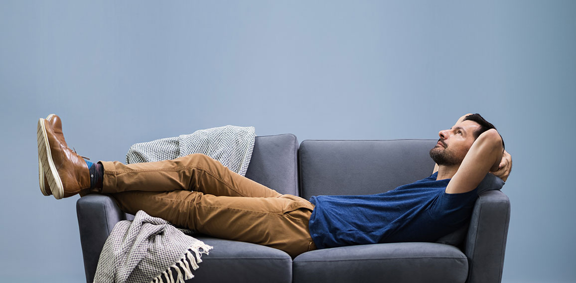 Man Relaxing On Sofa At Home