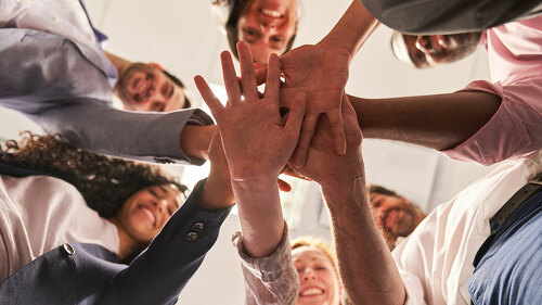 Gruppe Freunde als Startup Team beim Hände stapeln