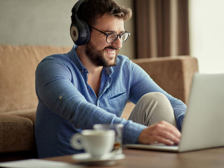man with headphones using laptop in his home