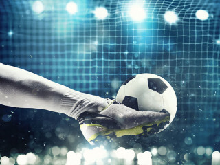 Close up of a soccer striker ready to kicks the ball in the football goal