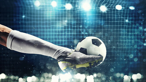 Close up of a soccer striker ready to kicks the ball in the football goal