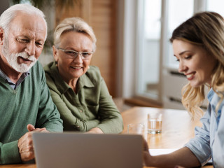 Senior couple talking to insurance agent at home