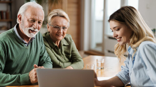 Senior couple talking to insurance agent at home