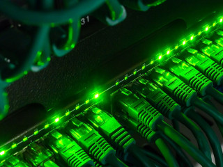 Close up of green network cables connected to switch glowing in the dark