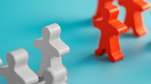 Two groups of wooden figures are standing in front of each other