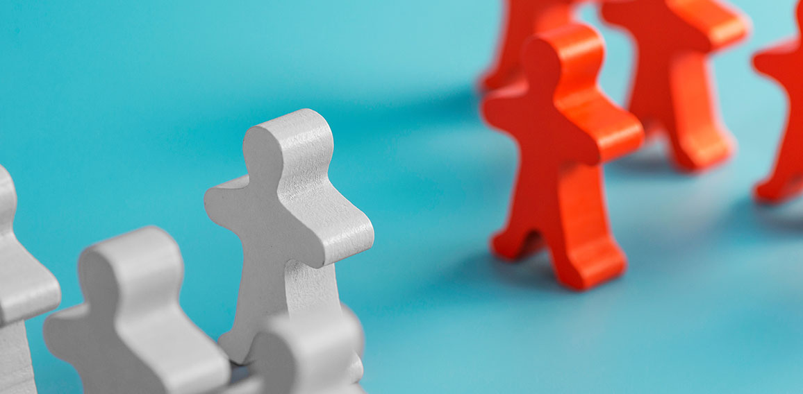 Two groups of wooden figures are standing in front of each other