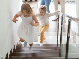 Children going upstairs to second floor their new modern house