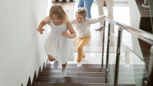 Children going upstairs to second floor their new modern house