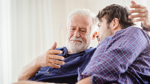 old man serious discussion with younger man indoor, grand father