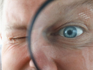 Smiling businessman hold magnifying glass