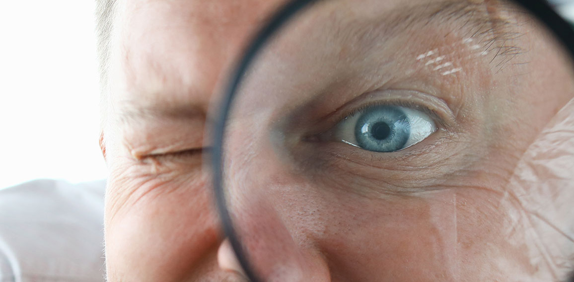 Smiling businessman hold magnifying glass