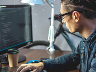Male programmer is writing program code on a laptop at home. The concept of software development