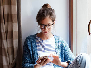 Young woman working from home office. Freelancer using laptop, phone and the Internet.