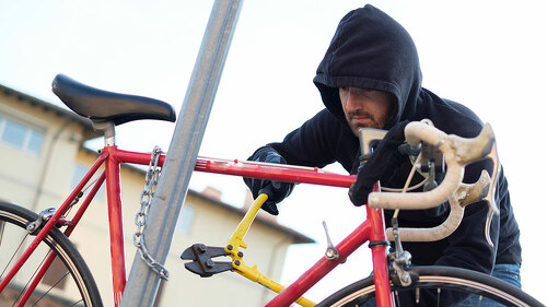 Thief stealing a bike in the city street