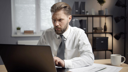 Concentrated businessman working on laptop
